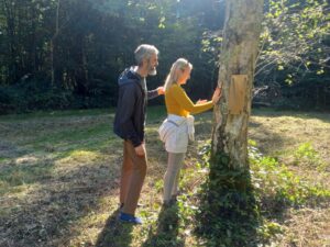 Two people standing in front of a tree