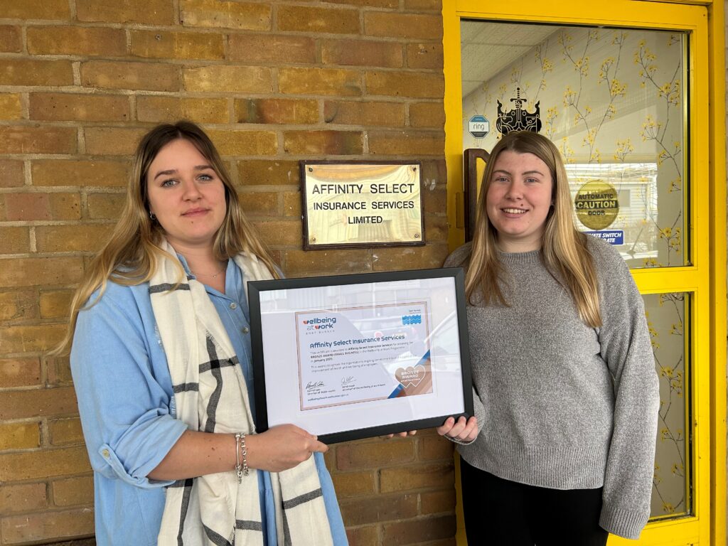 Two women holding a framed certificate for Small Business Bronze Award