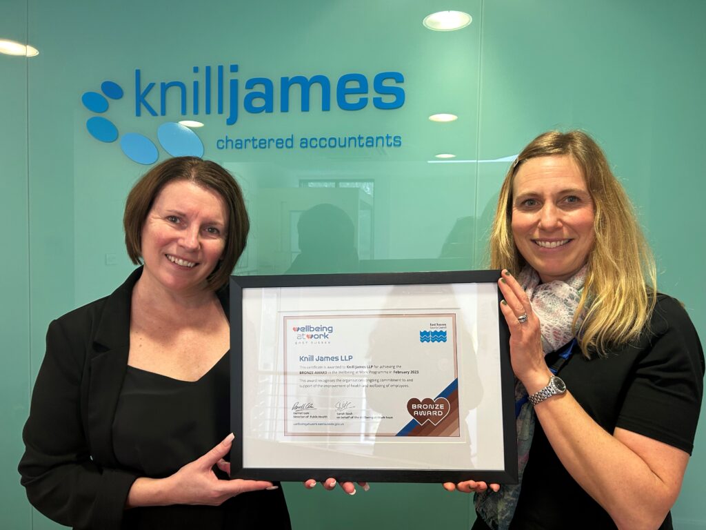 Two people holding a framed certificate for Bronze Award