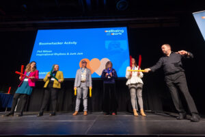 People on stage making music with boomwhackers